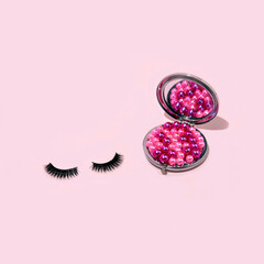 Inspirational idea of pink and violet decorations in a mirror with eyelashes. Minimal fashion makeup and cosmetic concept.