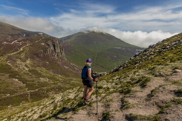 Female hiker looking towards Slieve Donard from Cove mountain, Mourne mountains area of outstanding natural beauty, County Down, Northern Ireland