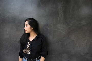 Asian woman with long hair facing side The background is a loft wall copy space