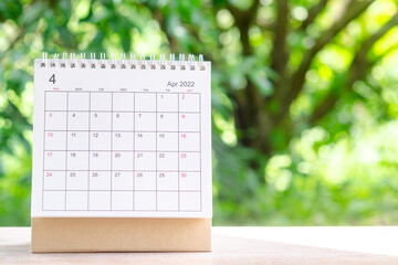 April month, Calendar desk 2022 for organizer to planning and reminder on wooden table with green...