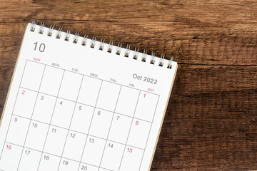 Top view calendar desk 2022, Calendar planning in October month on wooden table background.