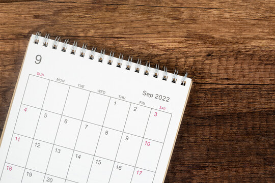 Top view calendar desk 2022, Calendar planning in September month on wooden table background.