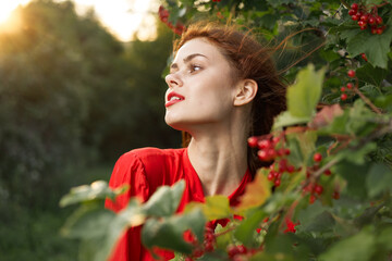 Naklejka premium pretty woman in red shirt nature green leaves summer