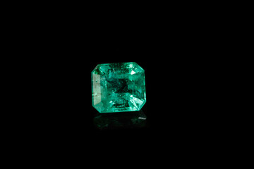 Macro mineral Emerald gemstone faceted on black background