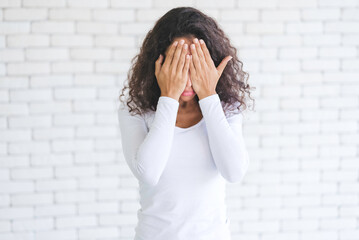 Portrait African American millennial women feeling stressed and worried after overwork. Younger females have symptoms of afflicted onset syndrome. Office workers are crying.