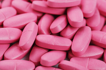 Obraz na płótnie Canvas Pink pills with multivitamins in full screen as a background.