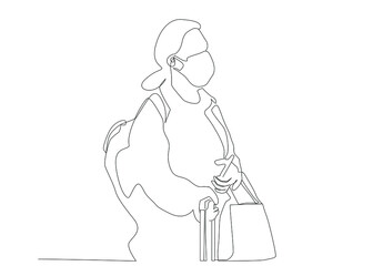 masked woman waiting with travel bag and backpack