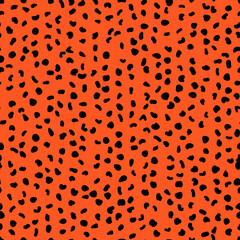 Abstract seamless pattern from small shapes. Simple background of irregular spots. Abstract wild animal skin print. Random spaced black spots. Vector illustration on deep orange background