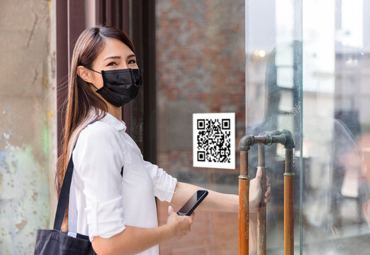 Young Woman Wearing Facemask And Scan QR Code With Smart Phone  Before Enter Stores.