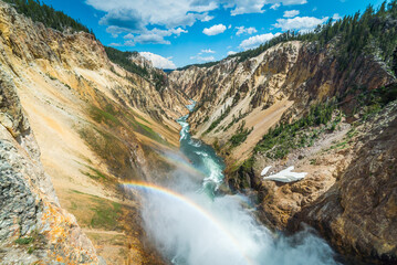 Fototapeta na wymiar Rainbow over the waterfall. Amazing mountain landscape. Big waterfall among the beautiful rocks. Brink of the Lower Falls on the Grand Canyon of the Yellowstone, Yellowstone National Park, Wyoming