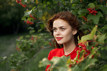 cheerful woman in a red shirt bush berries countryside