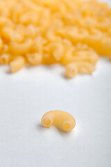 A bunch of uncooked chifferi pasta, chaotically assembled on a white background