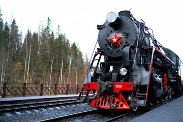 Republic of Karelia Russia - Soviet L-series steam locomotive with the Ruskealsky Express tourist train on the platform of the marble canyon railway station.
