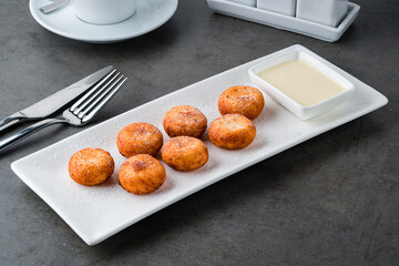 Homemade cottage cheese pancakes with condensed milk on gray background, breakfast