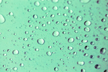 Fototapeta na wymiar Lots of small oxygen bubbles under the water. Turquoise clear transparent liquid background and texture. Drops of water or rain on a green surface, natural abstract backdrop. Fresh mineral water.