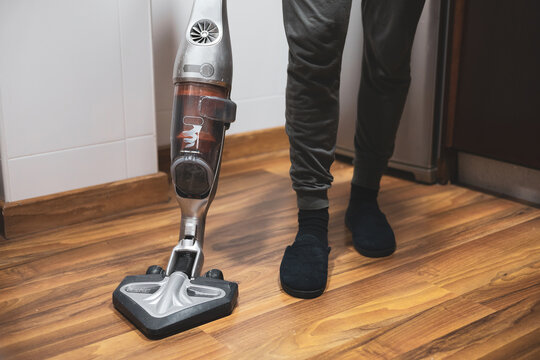 a man cleaning the vacuum cleaner in his kitchen.