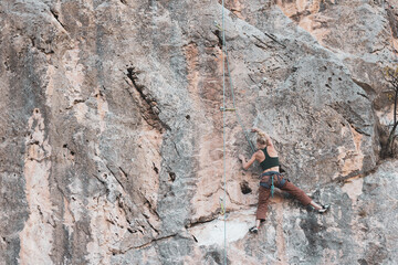 a girl climbing a rock in the open air.
