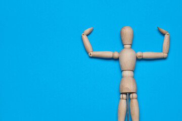 wooden figure mannequin object posing blue background