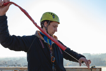 White male climber works on a high-rise building