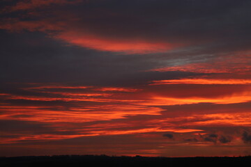 dramatic clouds in crimson color during sunrise