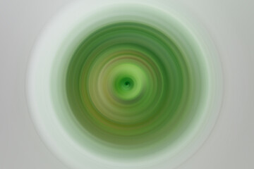 Fototapeta na wymiar Blurred dark green spin on light grey backdrop