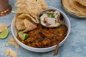Vegan indian bowl with mixed vegetable curry,, salad, flatbreads and crackers