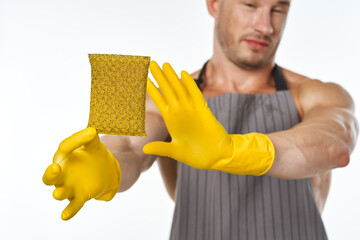 a man in a gray apron wearing rubber gloves cleaning washing