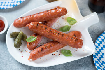 Grilled bratwurst sausages served on a white shovel-shaped plate, studio shot, middle close-up