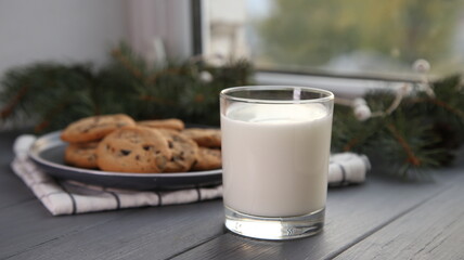 Milk and biscuits on a gray wooden background with place for text. Milk and cookies for Santa for Christmas