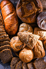 Assorted bakery products including loafs of bread and rolls - obrazy, fototapety, plakaty
