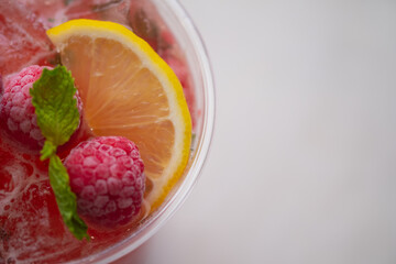 Summer refreshments in plastic glass decoration with slice lemon and berry