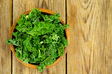 Fresh green sabellica leaves on wooden background, healthy organic food.