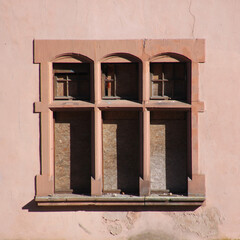 Neo-renaissance nailed shut windows frames at the facade of an abandoned villa in the town of Trier Ehrang in Germany
