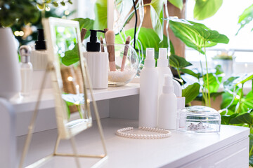 Reflection of christmas tree, light bulbs, in table mirror on woman dressing table with make up accessories