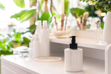 Woman daily cream on dressing table with make up accessories. Reflection of christmas tree, light bulbs in table mirror.