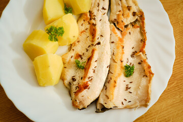 Trout filets with potatoes on plate top view