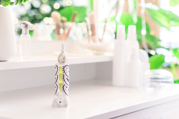 Woman applying perfume on her hand sitting near dressing table with make up accessories and table mirror. Self-Care.