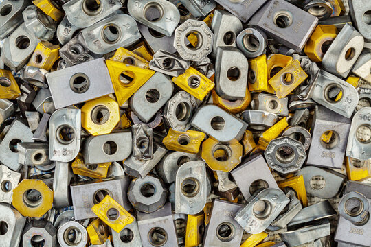 Gebrauchte Wendeschneidplatten zum Drehen oder Fr&auml;sen in Nahaufnahme von oben als Hintergrund