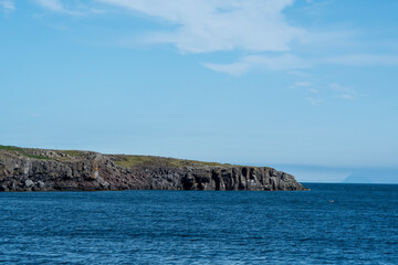 Landscape of cliffs rocky coast on sunny day in Keflavik Iceland