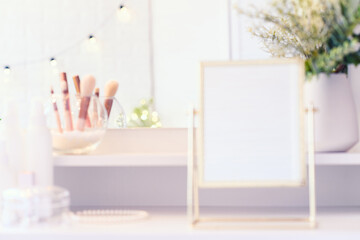 Table mirror on dressing table with make up accessories. Self-Care. White, pastel interior. Blurred backgraund