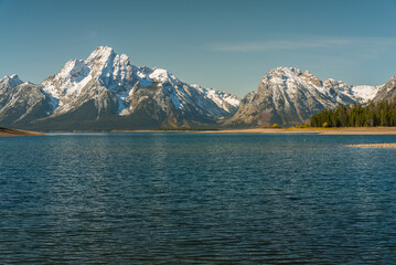 Beautiful snow-capped mountains near blue the lake. Jackson Lake, Wyoming, USA