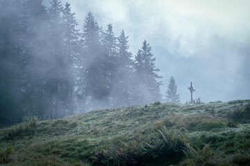 a cross in the mountains in the mist in mystical atmosphere at Pilatus, Switzerland