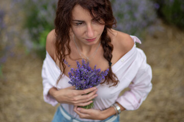 Closeup happy beautiful girl enjoying lavender field with bouquet of flowers