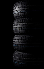 Fototapeta na wymiar stack of tires on black background