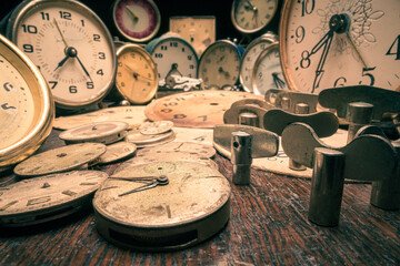 Fototapeta na wymiar Broken clocks and spare parts in workshop. Vintage watchmakers workshop.