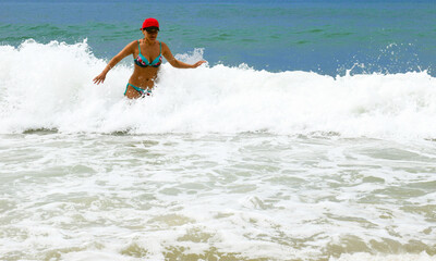 A girl swims in the sea. Beach holidays. Big waves. Tropical climate. A happy woman. - 467563041