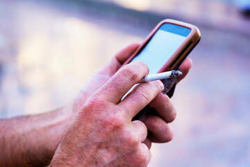 Smoker's portrait. close-up Man holding cigarette in his hand closeup outdoor.  Quit smoking. concept harm of smoking