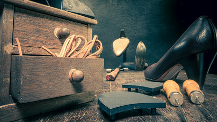 Traditional shoemaker workshop with tools, strap, leather and rules.