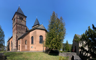 Fototapeta na wymiar Medieval church of St Peter and Paul with its romanesque bell towers in a park in the old town of Echternach, Luxemburg