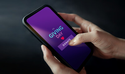 Online Donation, Charity and Volunteering Concept. Closeup of Hand Using a Mobile Phone to making...